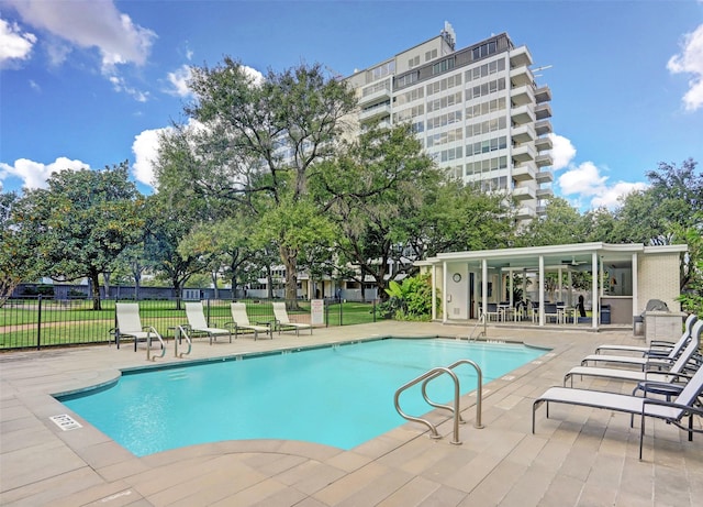 community pool featuring fence, a yard, and a patio area