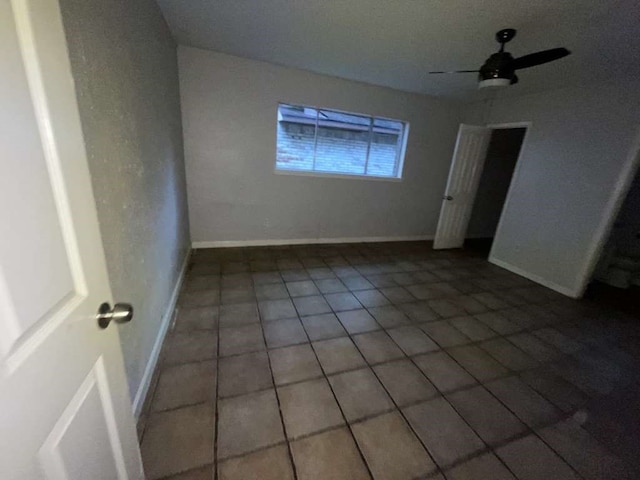 tiled spare room with ceiling fan