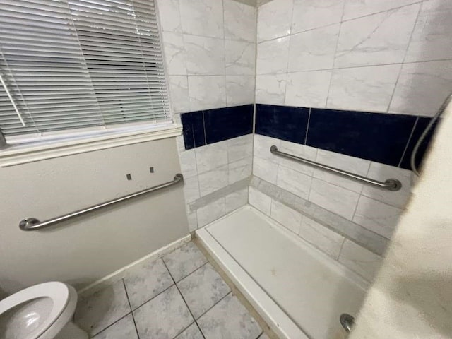 bathroom featuring toilet and tiled shower