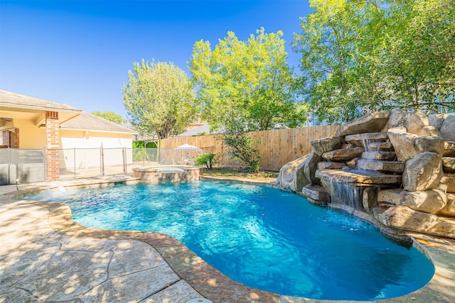 view of swimming pool with pool water feature and an in ground hot tub