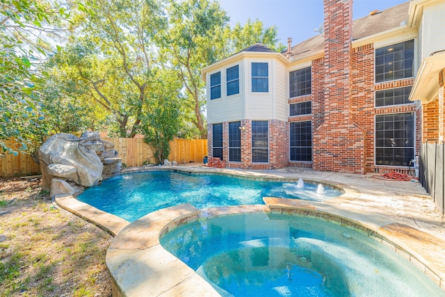 view of pool featuring an in ground hot tub and pool water feature