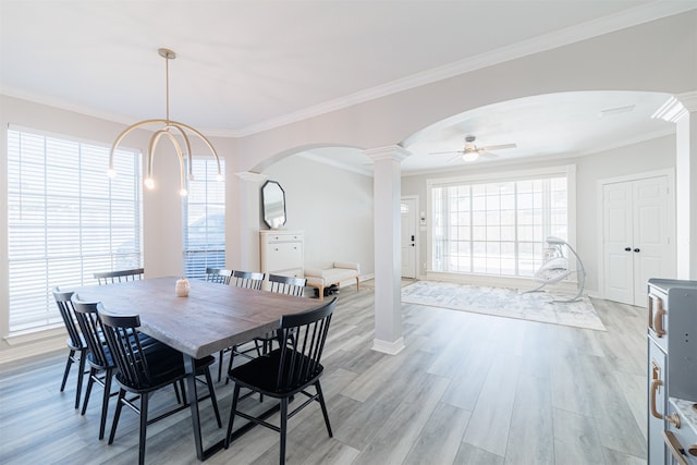 dining area with light hardwood / wood-style floors, ornamental molding, ceiling fan, and decorative columns