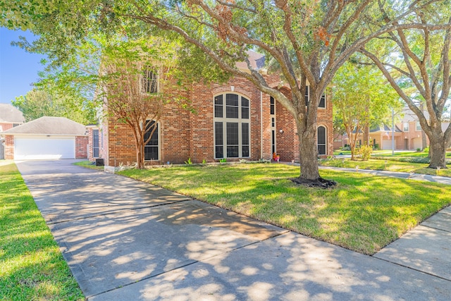 tudor-style house featuring a front yard and a garage