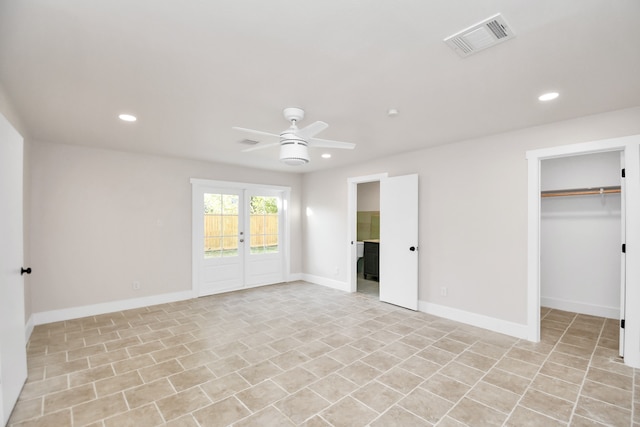 unfurnished bedroom with a closet, a spacious closet, and ceiling fan