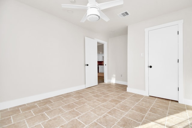 tiled spare room featuring ceiling fan