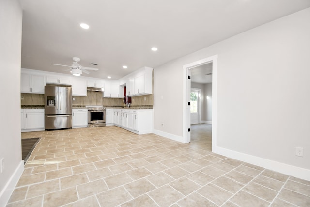 kitchen featuring stone counters, appliances with stainless steel finishes, ceiling fan, white cabinets, and decorative backsplash