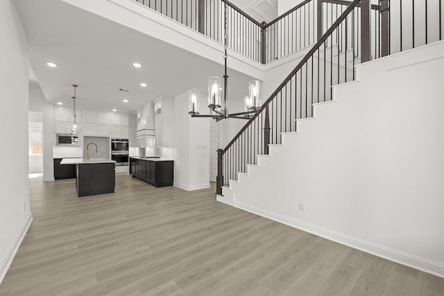 interior space featuring a high ceiling, hardwood / wood-style floors, and a notable chandelier