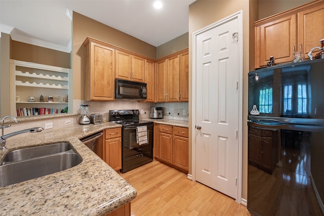 kitchen with sink, black appliances, light stone countertops, crown molding, and light hardwood / wood-style floors