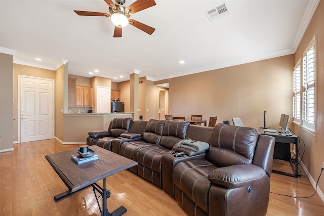 living room with light hardwood / wood-style floors, crown molding, and ceiling fan