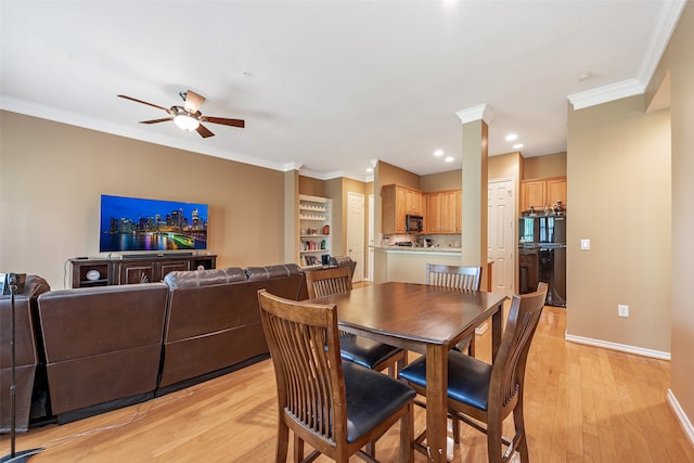 dining space featuring ornamental molding, light wood-type flooring, and ceiling fan