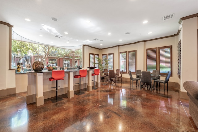 interior space with a kitchen breakfast bar and crown molding