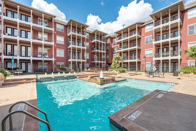 view of swimming pool featuring a hot tub and pool water feature