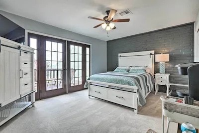 bedroom featuring french doors, a barn door, light carpet, and ceiling fan