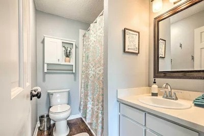 bathroom with hardwood / wood-style floors, a textured ceiling, toilet, vanity, and a shower with shower curtain