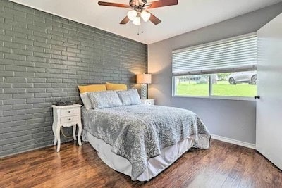 bedroom featuring brick wall, dark wood-type flooring, and ceiling fan