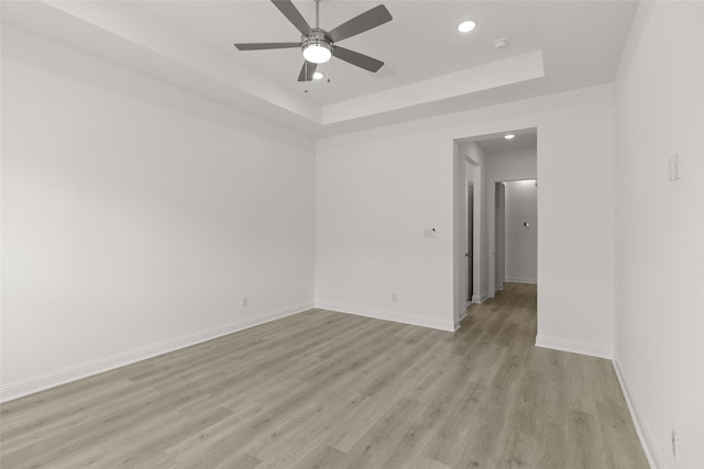 22067 Breakwater Ln, Porter, TX 77365 - empty room featuring light wood finished floors, ceiling fan, a tray ceiling, baseboards, and recessed lighting
