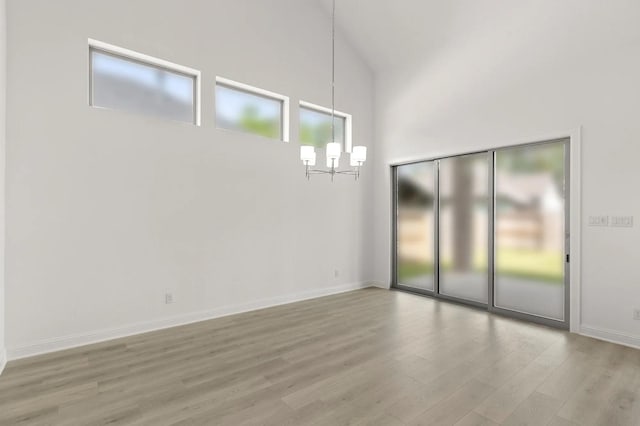 22067 Breakwater Ln, Porter, TX 77365 - spare room with a chandelier, wood finished floors, a towering ceiling, and baseboards
