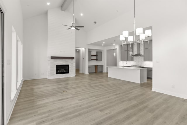 22067 Breakwater Ln, Porter, TX 77365 - unfurnished living room featuring high vaulted ceiling, a sink, light wood-style floors, recessed lighting, and beamed ceiling