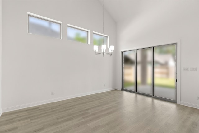 22067 Breakwater Ln, Porter, TX 77365 - unfurnished room with light wood-style floors, a chandelier, a towering ceiling, and baseboards