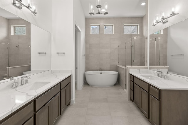 22067 Breakwater Ln, Porter, TX 77365 - full bathroom featuring two vanities, a stall shower, a freestanding bath, toilet, and a chandelier