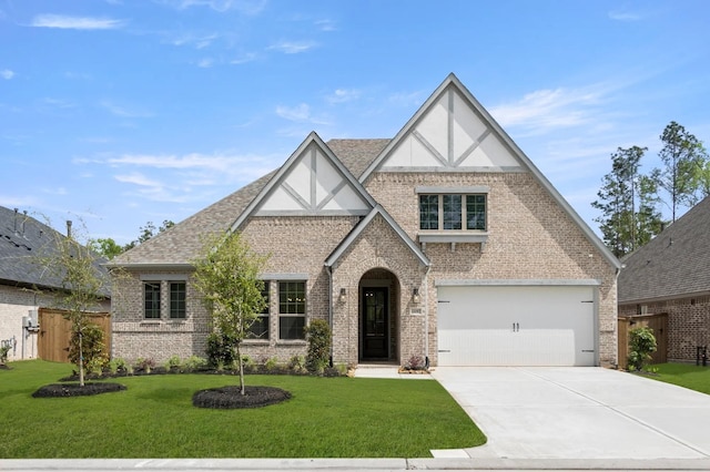 22067 Breakwater Ln, Porter, TX 77365 - tudor home featuring brick siding, concrete driveway, stucco siding, an attached garage, and roof with shingles