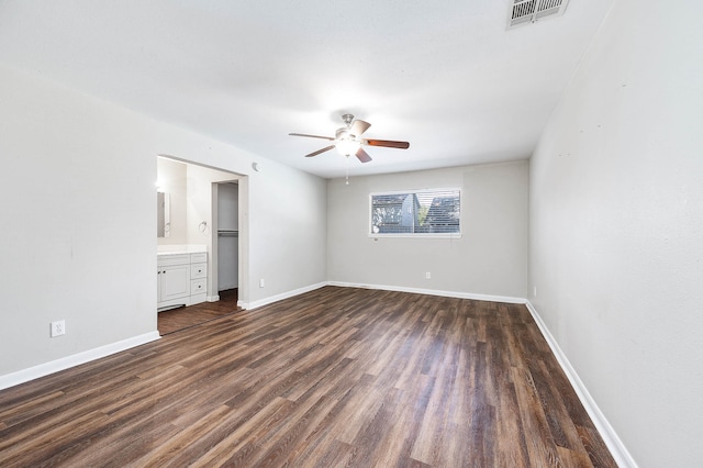 unfurnished bedroom featuring dark wood-type flooring, connected bathroom, and ceiling fan