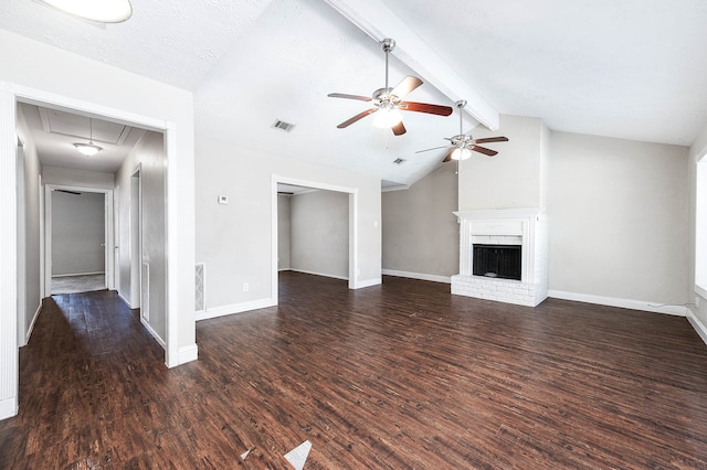 unfurnished living room with vaulted ceiling with beams, a brick fireplace, dark wood-type flooring, and ceiling fan