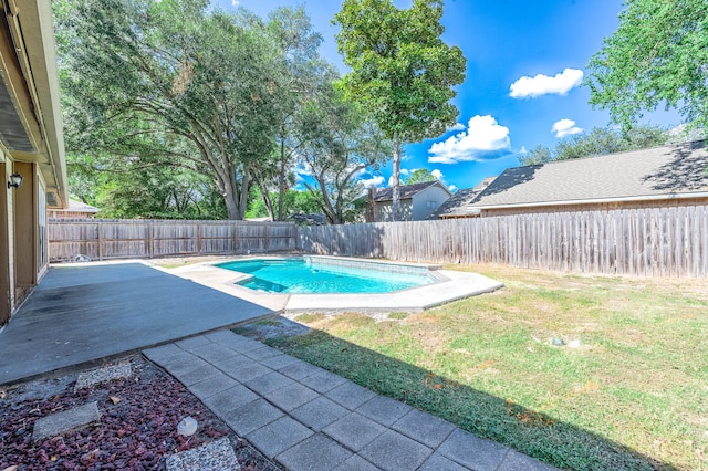 view of pool with a patio and a lawn