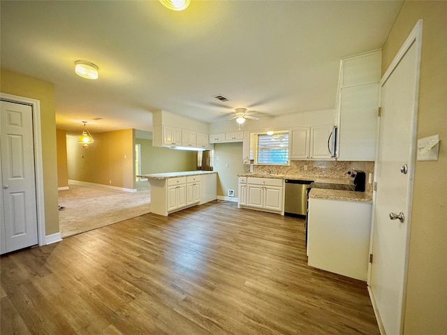 kitchen with light countertops, stainless steel appliances, baseboards, a ceiling fan, and backsplash