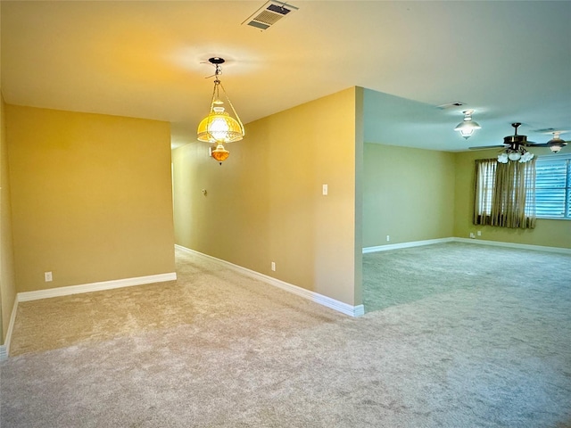 carpeted empty room with a ceiling fan, baseboards, and visible vents
