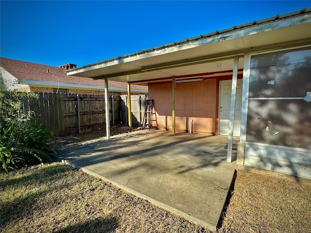back of house featuring fence and a carport