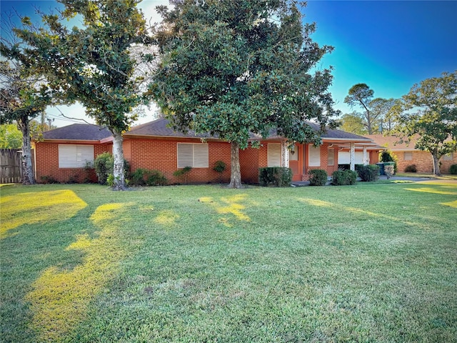 ranch-style home featuring fence, a front lawn, and brick siding