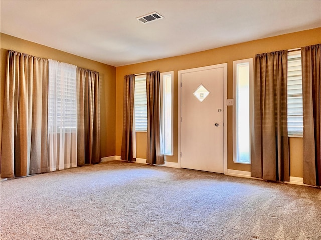 foyer with baseboards, carpet flooring, and visible vents