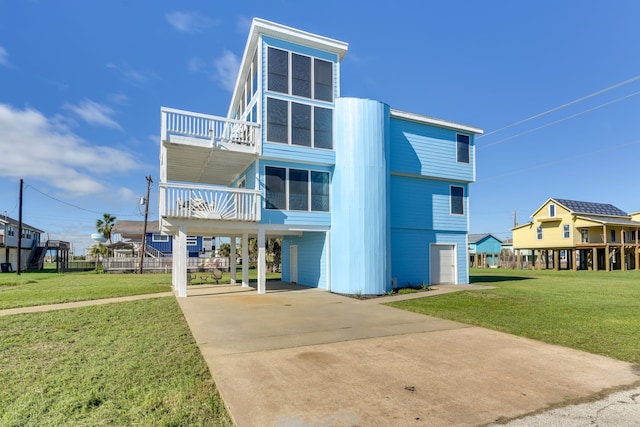 view of front of house with a balcony, a garage, a front lawn, and a carport