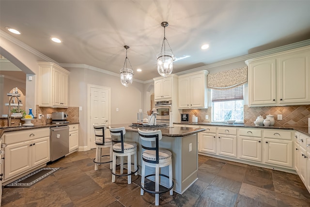 kitchen with pendant lighting, a center island, backsplash, sink, and stainless steel appliances