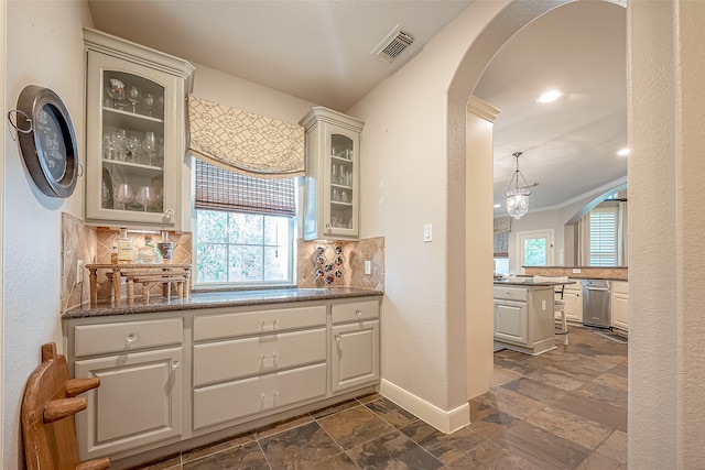 interior space featuring dishwasher, backsplash, decorative light fixtures, and crown molding