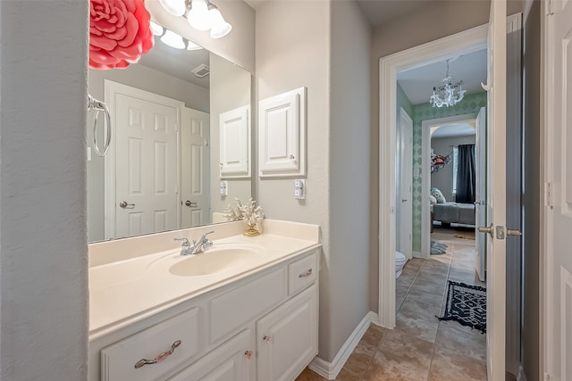 bathroom featuring a chandelier, tile patterned floors, vanity, and toilet