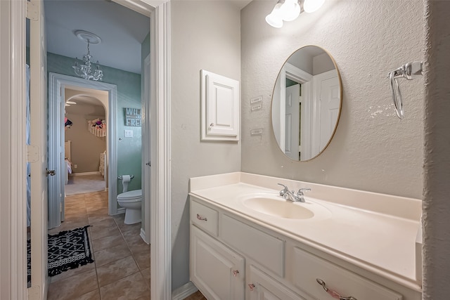 bathroom with tile patterned flooring, vanity, and toilet