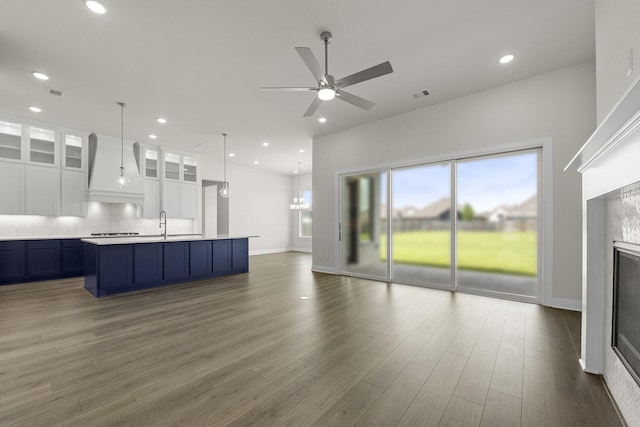 4707 Arbor Park Dr, Manvel, TX 77583 - kitchen with premium range hood, open floor plan, a ceiling fan, light countertops, and decorative backsplash