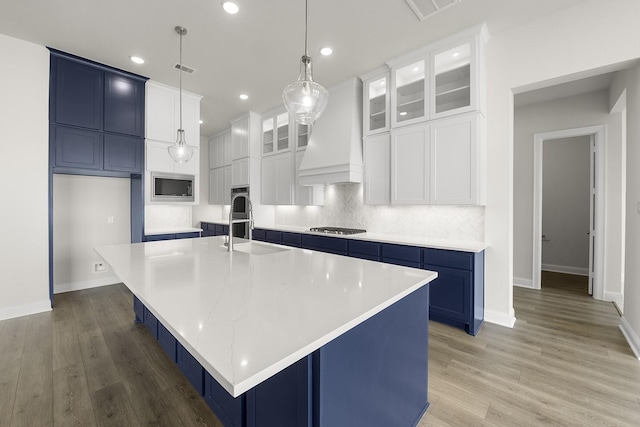 4707 Arbor Park Dr, Manvel, TX 77583 - kitchen featuring blue cabinetry, a sink, recessed lighting, a large island, and light countertops