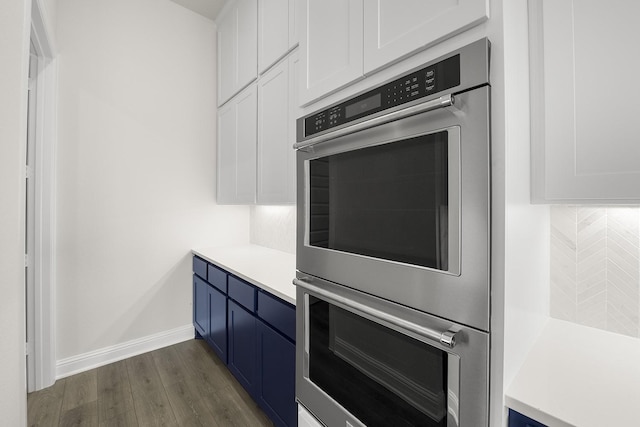 4707 Arbor Park Dr, Manvel, TX 77583 - kitchen with stainless steel double oven, white cabinetry, light countertops, and dark wood finished floors