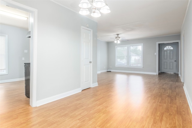 unfurnished living room with ornamental molding, ceiling fan with notable chandelier, and light hardwood / wood-style floors