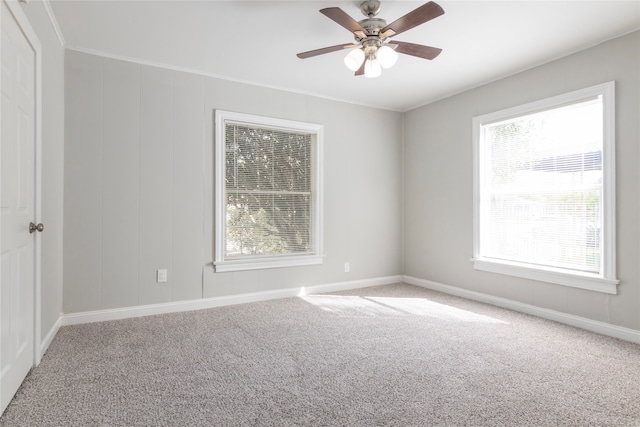 carpeted spare room featuring ceiling fan