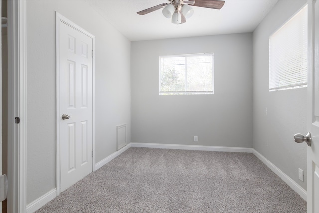 carpeted spare room featuring ceiling fan