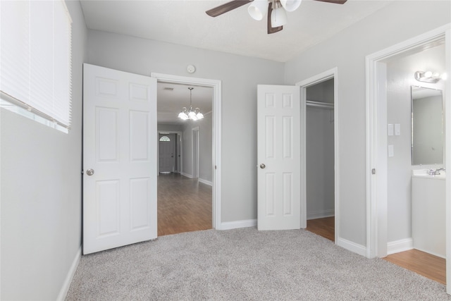 unfurnished bedroom featuring a closet, ensuite bath, carpet, and ceiling fan