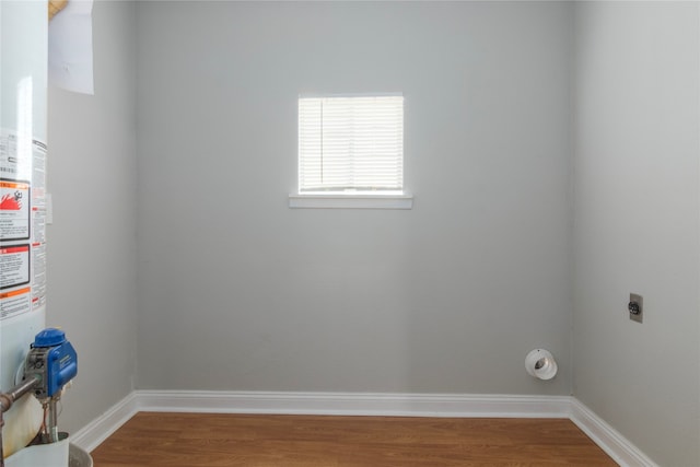 clothes washing area featuring hardwood / wood-style flooring and electric dryer hookup