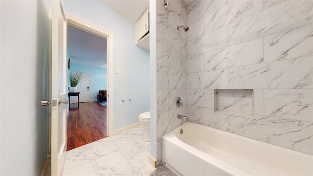 bathroom with toilet, tiled shower / bath combo, and hardwood / wood-style floors