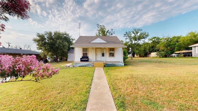 bungalow with covered porch and a front lawn