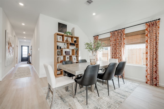 dining room featuring lofted ceiling and light wood-type flooring