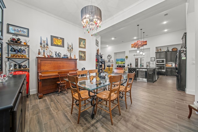 dining room with wine cooler, ornamental molding, a chandelier, and wood-type flooring